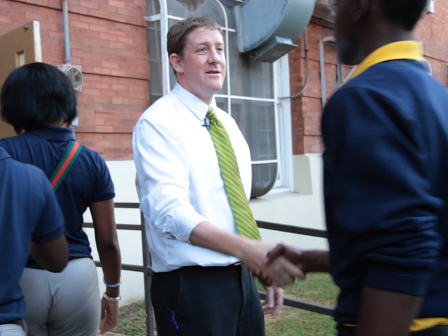 A KIPP Principal greets students before school