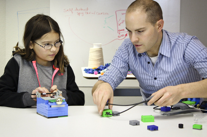 ATOMS University member works with Eric Budd, founding team member, to build a LEGO garage with a door that opens - using ATOMS.