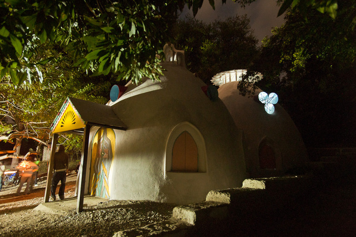 Community Center by night. Upper windows were created by welding beautiful patterns into recycled steel metal drum configurations.