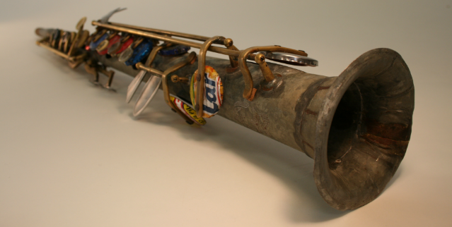 Tin water pipe, metal bottle caps, plastic buttons, metal spoon and fork handles. Tito Romero, maker