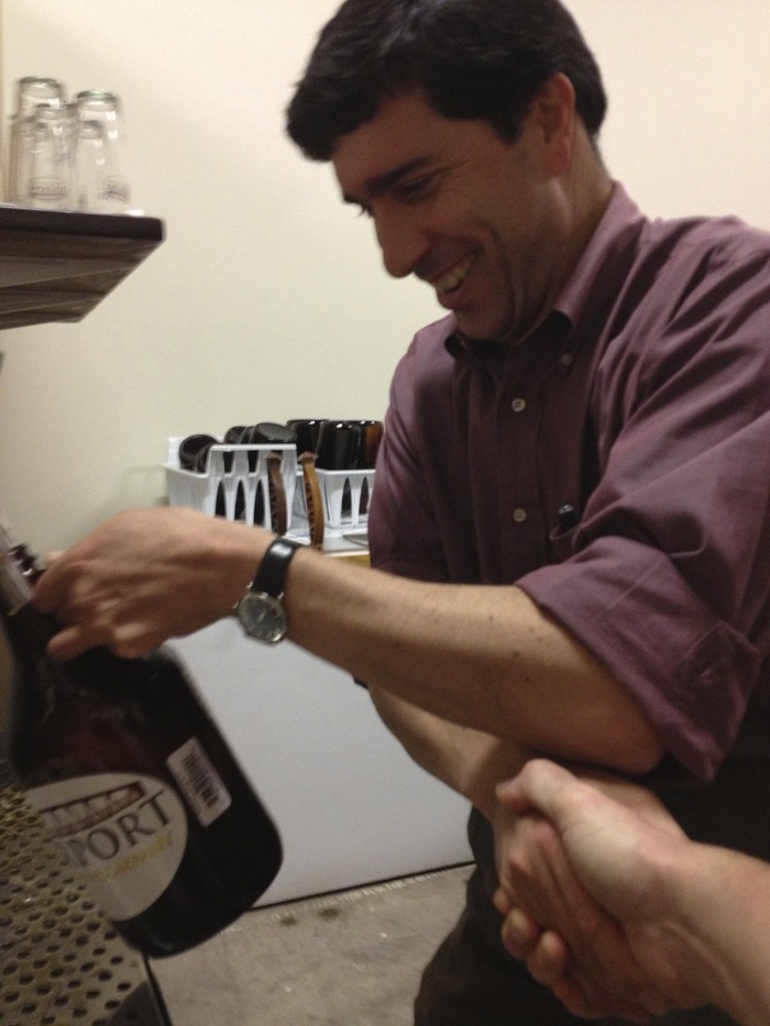 Paul filling the first growler sold by the Fairport Brewing Company and shaking Tim's hand!