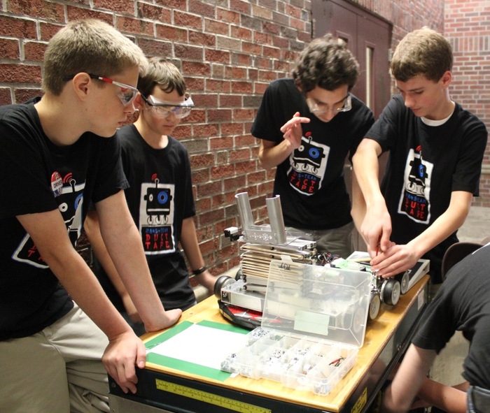 The TDT mechanical team performs a little hallway robot surgery between matches at a competition.