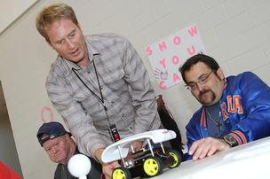 ROBAUTO "Chief Human" Jalali Hartman works with members of the ONE Robotics Engineering Team testing out the first prototype.