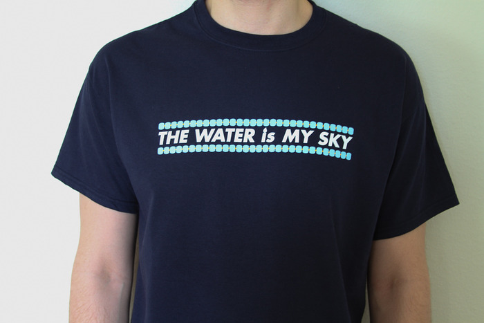 Add a little color to your wardrobe with our navy blue 'Water Is My Sky' T-shirt!